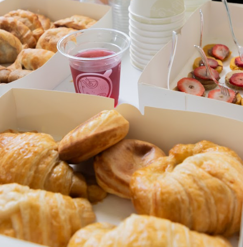 Cajas de catering con croissants, pasteles y una bebida en GROU