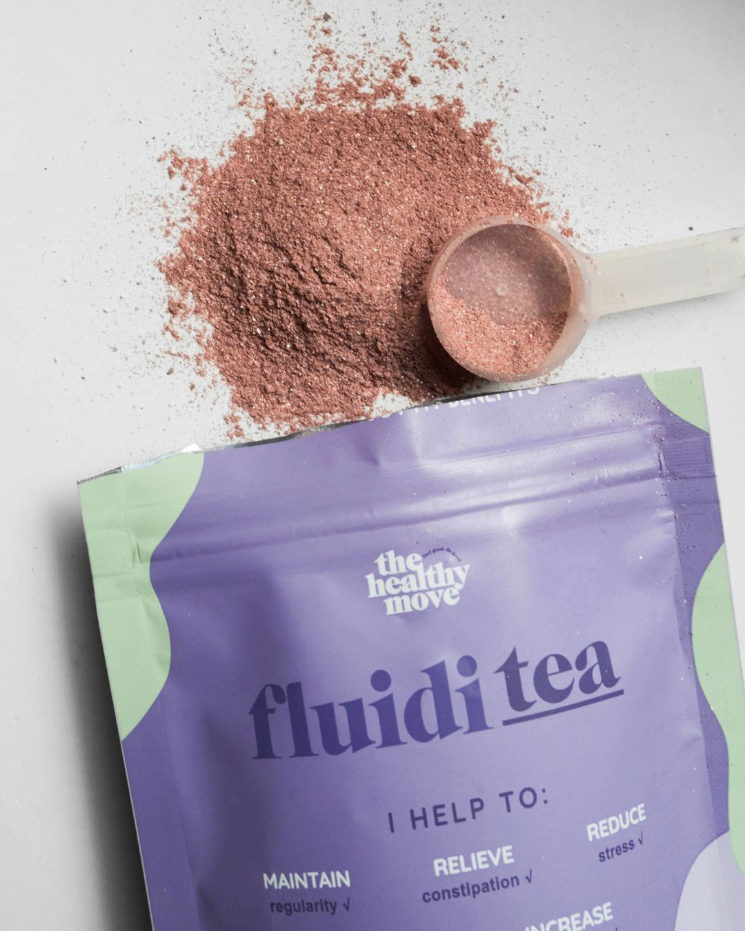 Envase de FluidiTEA junto a la mezcla en polvo y su cuchara medidora