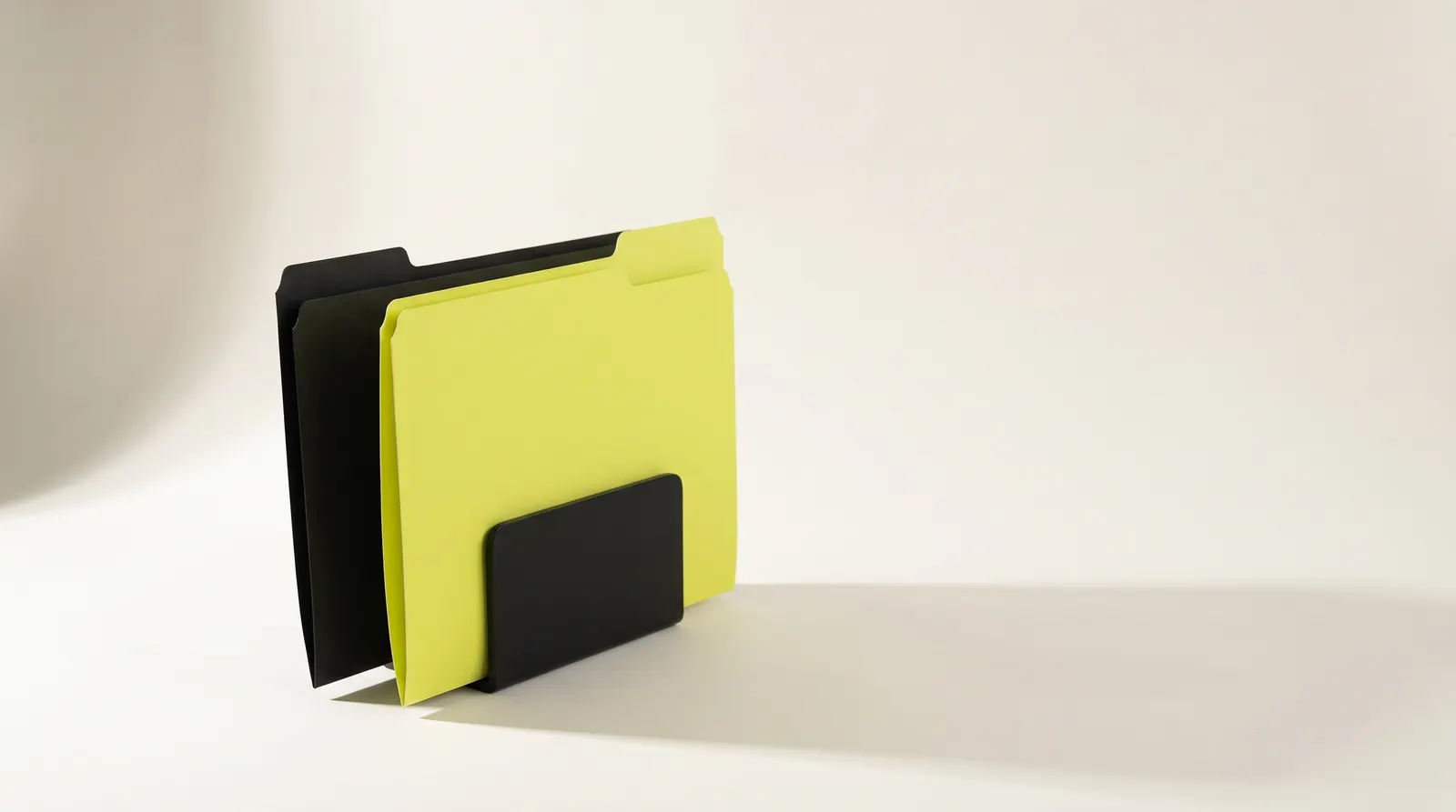 Two blank file folders standing in a black desk holder, one black and one lime, like one folder per language on a website.
