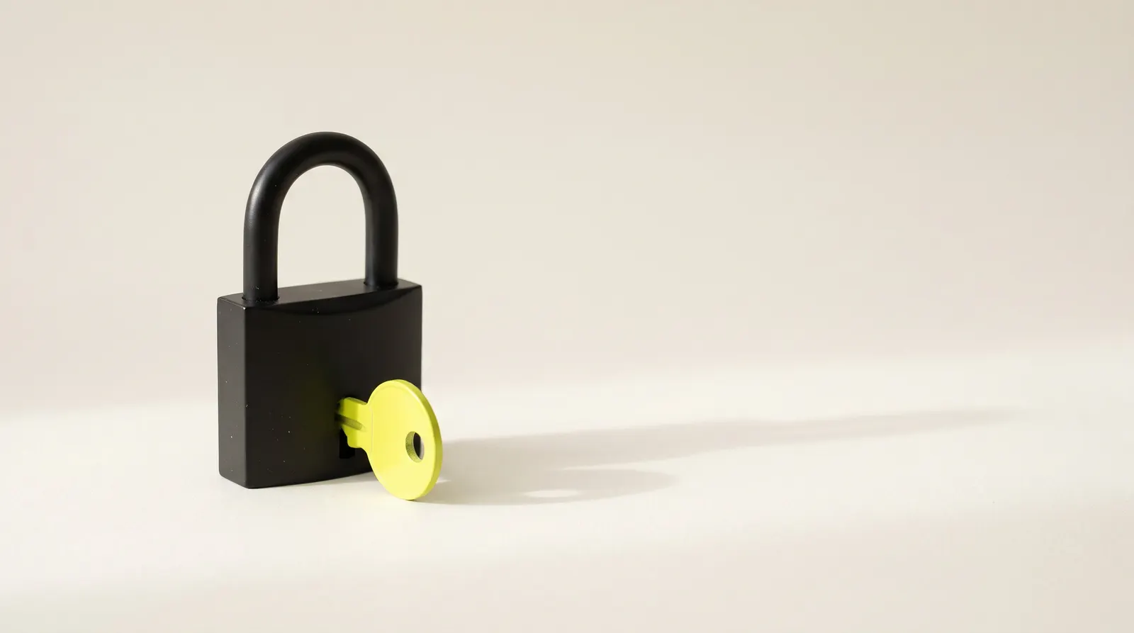Candado negro cerrado con una llave verde lima puesta en la cerradura.