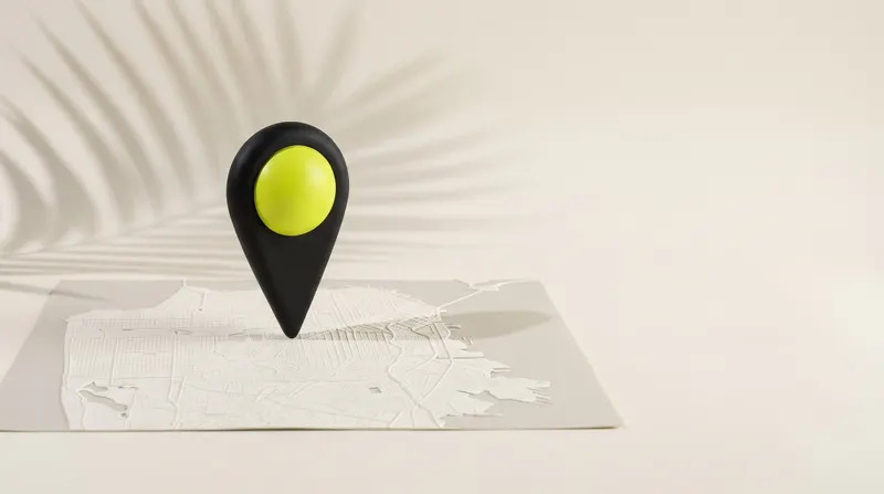 Marcador de mapa negro con cabeza verde lima sobre un mapa en relieve, con la sombra de una hoja de palmera.