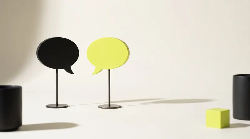 Two blank speech bubbles standing face to face on thin stands, one black and one lime, like two languages on one site.